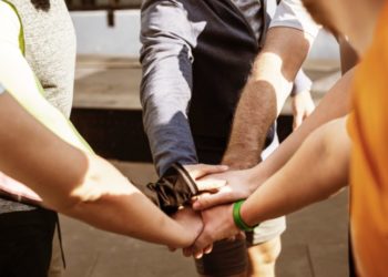 Coach et solidarité : personnes qui se tiennent la main au milieu d'un cercle