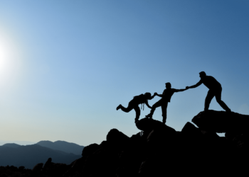 silhouettes de 3 personnes entrain de se tenir sur des rochers