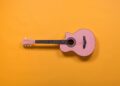 guitare rose sur fond orange
