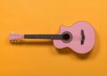 pink guitar on orange background