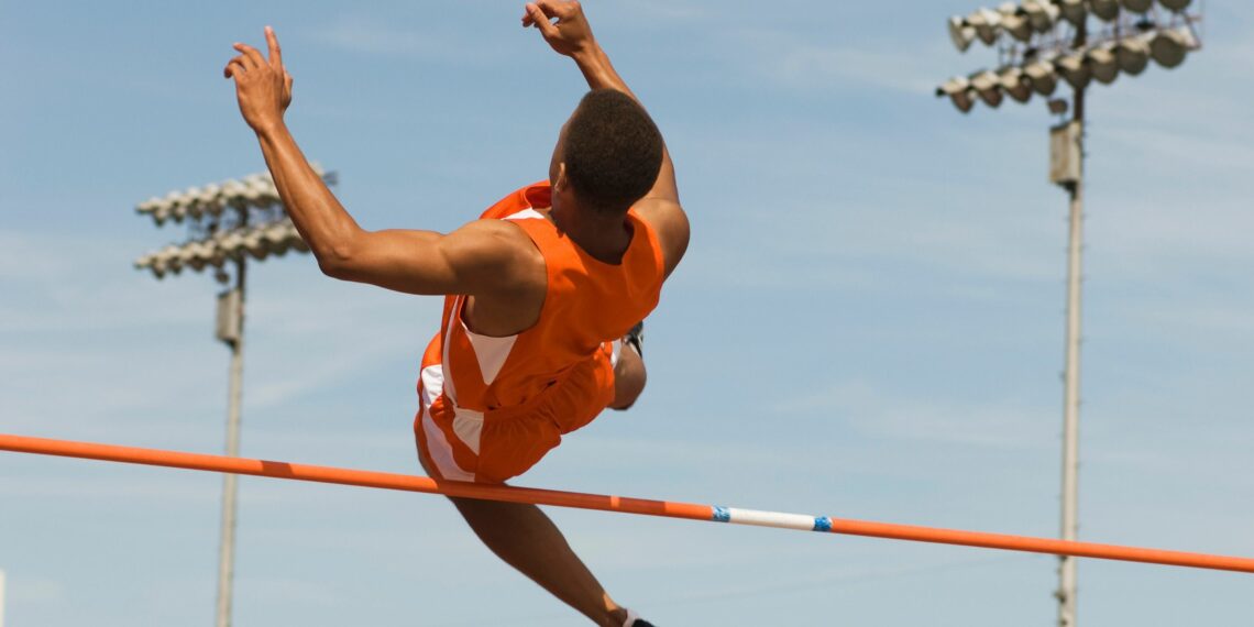 athlète sautant par dessus une barre