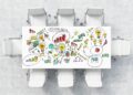 A white meeting table with graphics and data on top of it. 8 chairs around the table on a concrete floor.