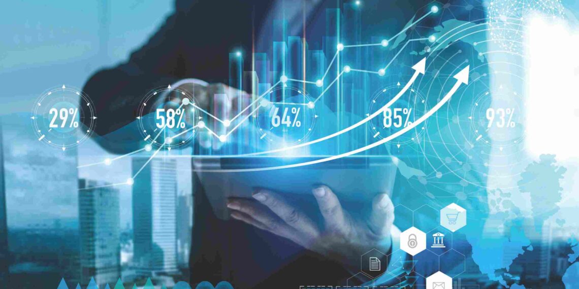 Personne en costume qui tient une tablette numérique. Des chiffres et graphiques d'un bleu néon ressortent de l'écran