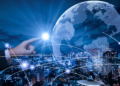 une main qui touche un globe terrestre. Le fond est une skyline d'une grande ville de nuit